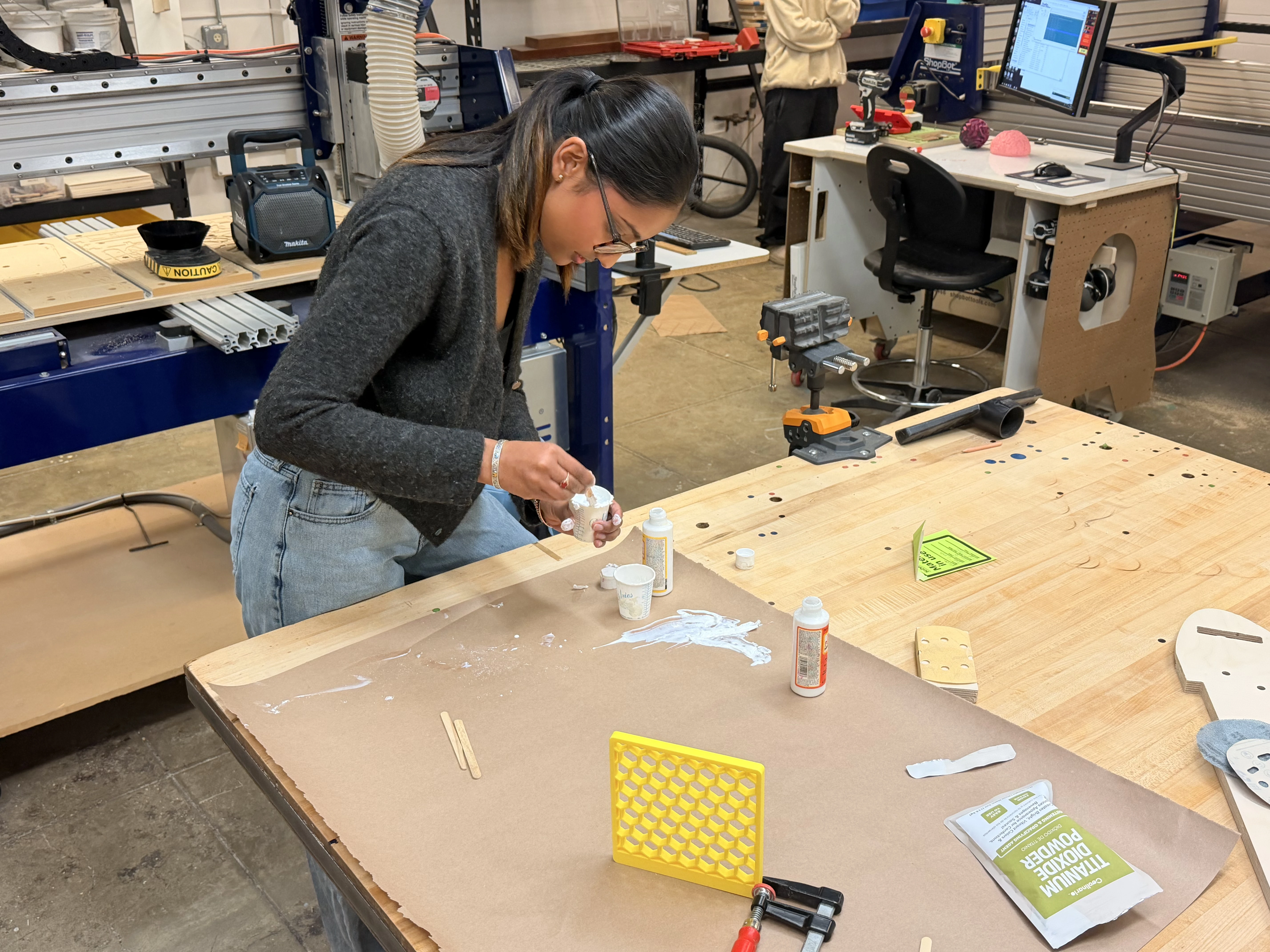 Mixing and applying titanium dioxide paste to a 3D-printed panel in the workshop